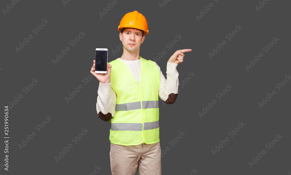 the man in a helmet with phone, points a finger aside