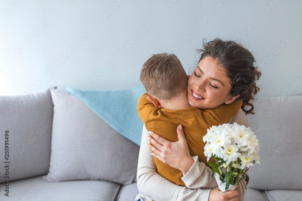 Mother and her little son with bouquet of flowers, Happy family mom and kid kissing and hugging. Mother's day gift. Mother and her little son with bouquet of flowers, Happy family mom and kid kissing and hugging. Mother's day gift.