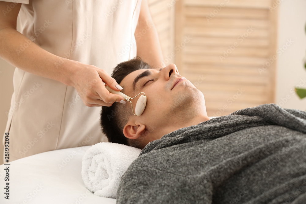 Man receiving face massage in beauty salon Man receiving face massage in beauty salon