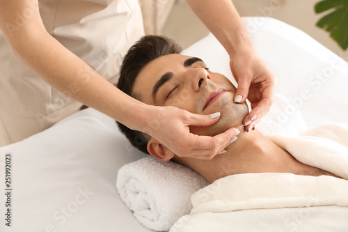Fotografie Man receiving face massage in beauty salon