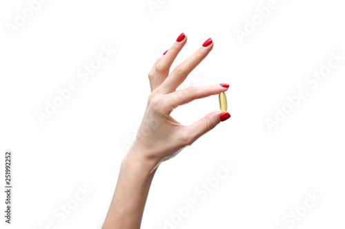 Hand holding capsule of Omega 3 on white background. Close up. High resolution product. Health care concept