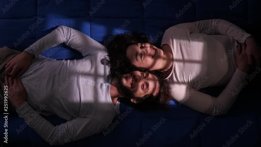 falling in love, flirting, romance.Smiling young lovers talking lying on bed falling in love, flirting, romance.Smiling young lovers talking lying on bed