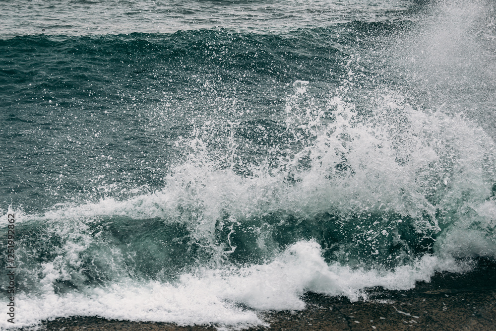 Sea waves splash at coastline, stormy sea water with foam motion