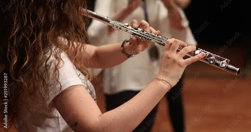 young woman playing flute, clarinet, classical music concert