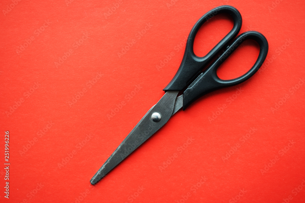 Stationery scissors with plastic handles on a red background Stationery scissors with plastic handles on a red background