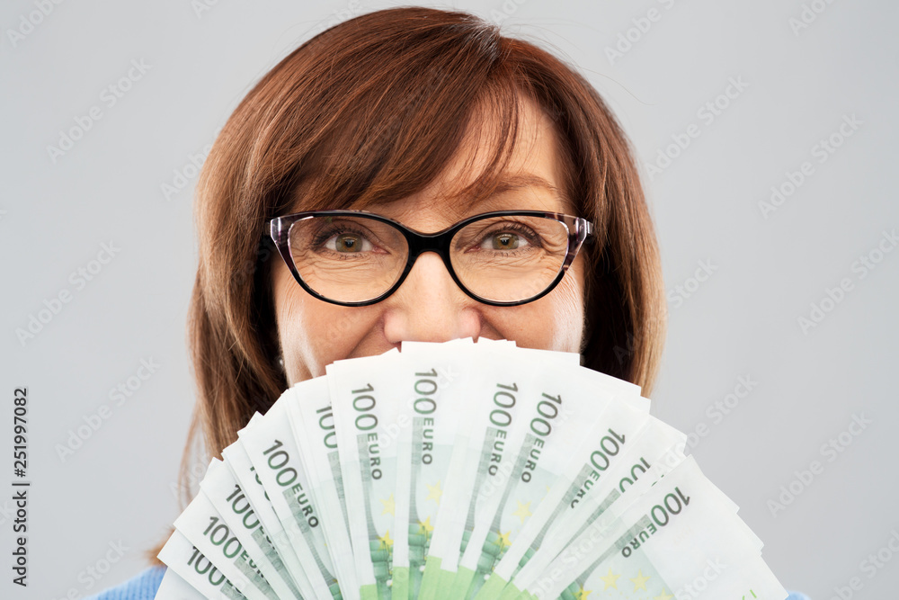 savings, finances and people concept - close up of smiling senior woman holding hundreds of euro money banknotes savings, finances and people concept - close up of smiling senior woman holding hundreds of euro money banknotes