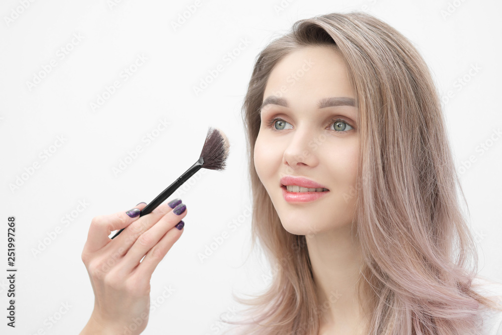 Make-up artist makes makeup beautiful blonde girl on a white background. Close-up hands with brush and face. Make-up artist makes makeup beautiful blonde girl on a white background. Close-up hands with brush and face.