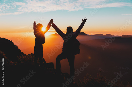 happy mother and son travel in mountains at sunset