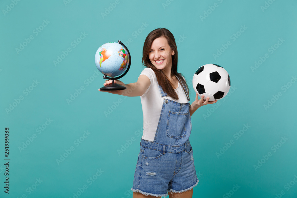 Pretty young woman football fan support favorite team with soccer ball, world globe isolated on blue turquoise background. People emotions, sport family leisure lifestyle concept. Mock up copy space. Pretty young woman football fan support favorite team with soccer ball, world globe isolated on blue turquoise background. People emotions, sport family leisure lifestyle concept. Mock up copy space.