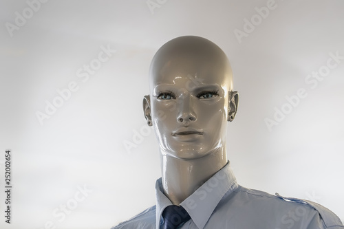 Head of a bald mannequin with a shirt on.