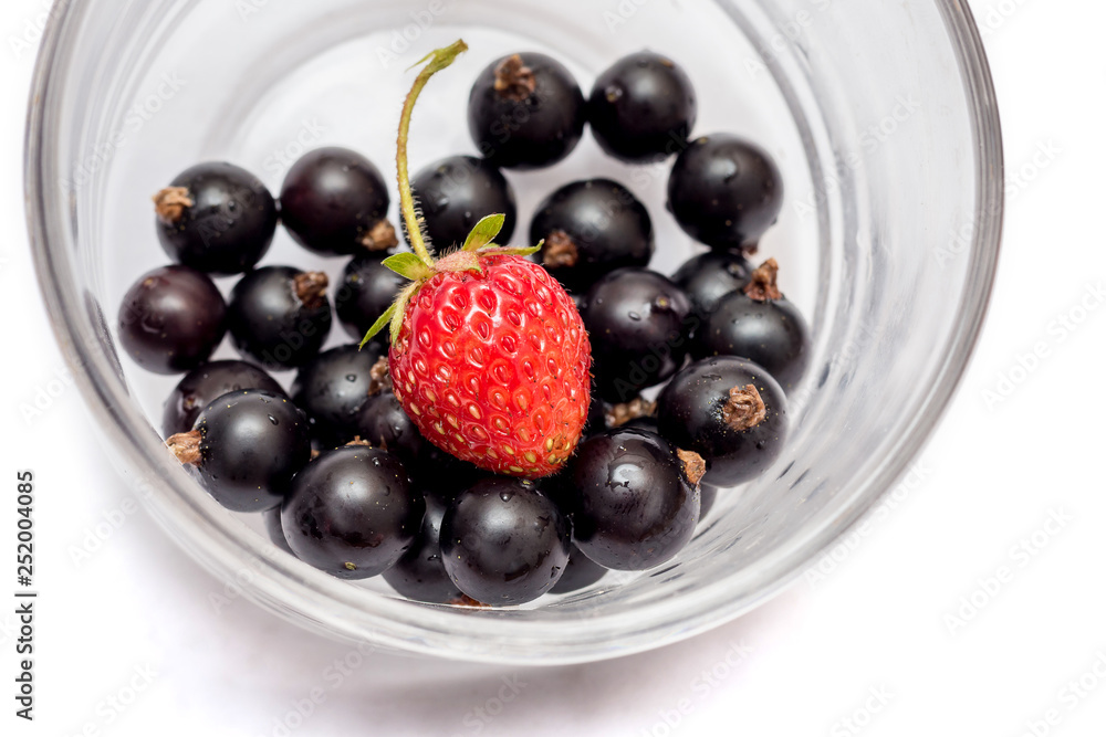Currant and strawberries in glass cup closeup on a white isolated background_ Currant and strawberries in glass cup closeup on a white isolated background_