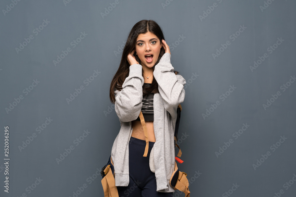 Teenager traveler girl over wall nervous and scared stretching hands to the front Teenager traveler girl over wall nervous and scared stretching hands to the front