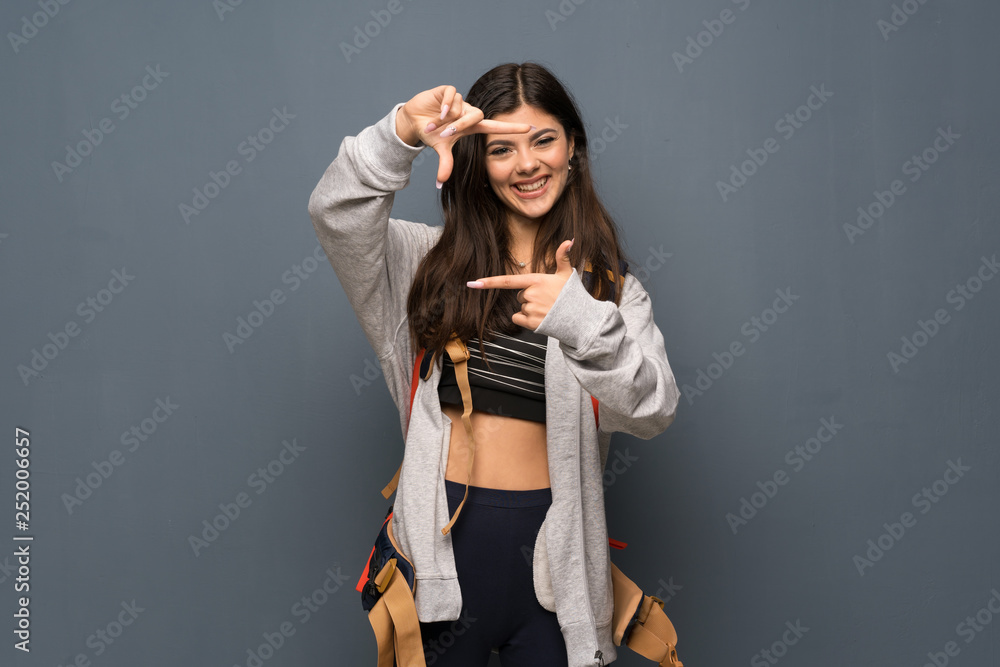 Teenager traveler girl over wall focusing face. Framing symbol Teenager traveler girl over wall focusing face. Framing symbol