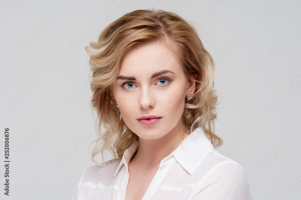 Portrait of serious curly woman in white shirt in studio. Portrait of serious curly woman in white shirt in studio.