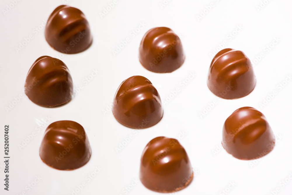 A lot of variety chocolates on white wooden background A lot of variety chocolates on white wooden background