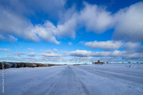 Beautiful snowy road in winter under blue sky