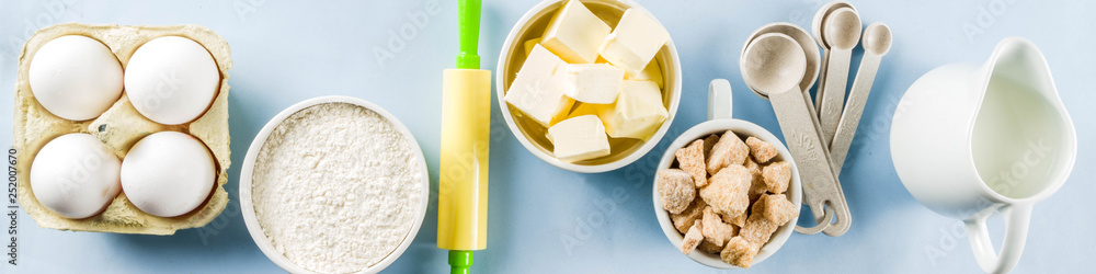 Baking ingredients and tools on trendy bright blue background - flour, eggs, sugar, milk, butter, layout, flatlay top view copy space banner Baking ingredients and tools on trendy bright blue background - flour, eggs, sugar, milk, butter, layout, flatlay top view copy space banner