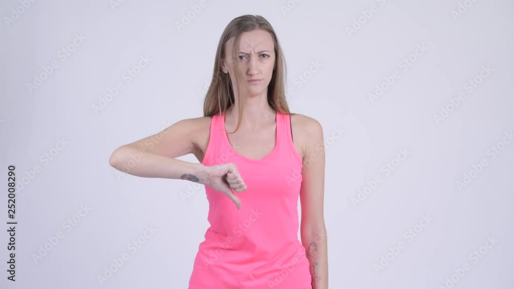 Portrait of angry blonde woman giving thumbs down Portrait of angry blonde woman giving thumbs down