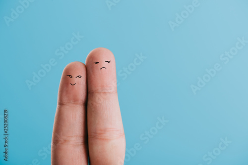 cropped view of fingers as dissatisfied couple isolated on blue