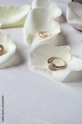 Golden rings on a white petals of roses.
