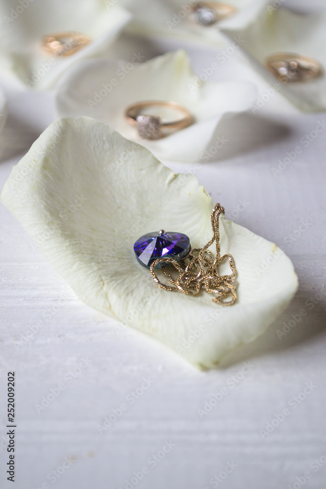 Necklace and gold rings on a white petals of roses. Necklace and gold rings on a white petals of roses.