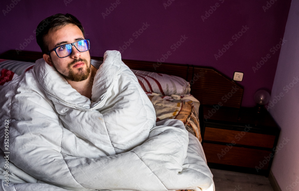 BOY MAN WITH THE BLANKET IN THE BED, IN THE FULL MORNING LIGHT