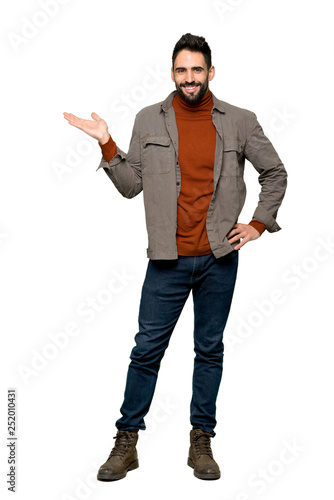 Full-length shot of Handsome man with beard holding copyspace imaginary on the palm to insert an ad on isolated white background
