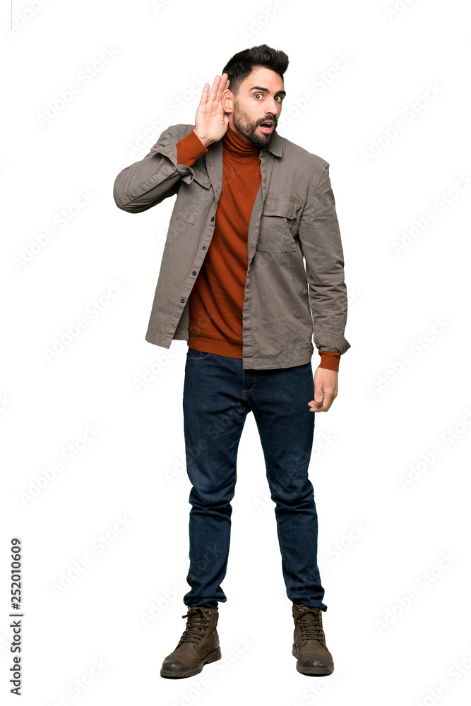 Full-length shot of Handsome man with beard listening to something by putting hand on the ear on isolated white background Full-length shot of Handsome man with beard listening to something by putting hand on the ear on isolated white background