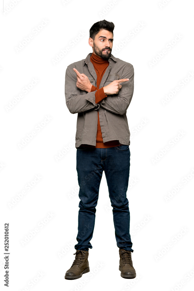Full-length shot of Handsome man with beard pointing to the laterals having doubts on isolated white background Full-length shot of Handsome man with beard pointing to the laterals having doubts on isolated white background