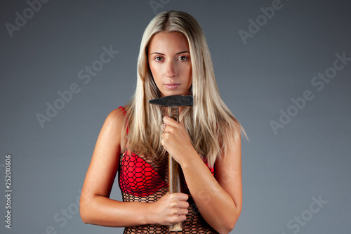 Sex equality and feminism. Sexy girl holding hammer tool. Girl is going to do repair with their own hands