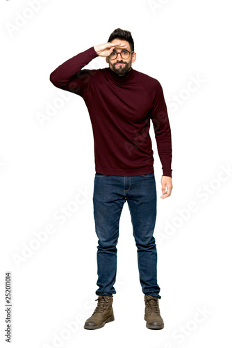 Full-length shot of Handsome man with glasses looking far away with hand to look something on isolated white background