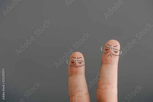 cropped view of dissatisfied fingers in glasses isolated on grey