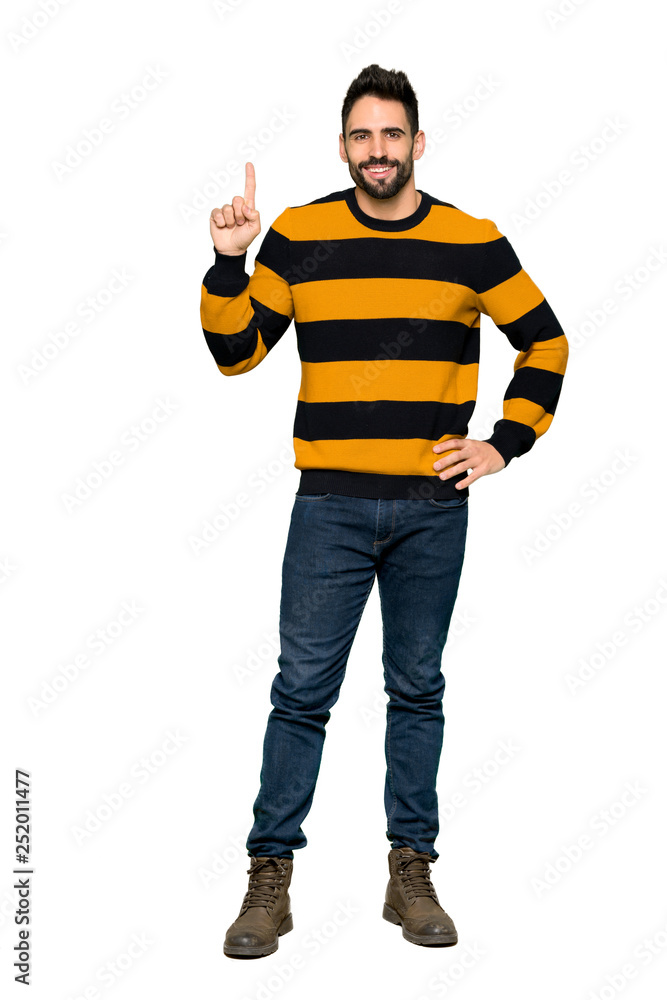 Full-length shot of Handsome man with striped sweater showing and lifting a finger in sign of the best on isolated white background Full-length shot of Handsome man with striped sweater showing and lifting a finger in sign of the best on isolated white background