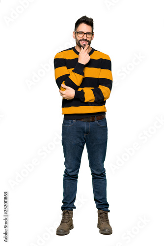Full-length shot of Handsome man with striped sweater with glasses and smiling on isolated white background