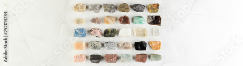 Set of minerals, a collection of rocks, minerals in the box on white cement background.
