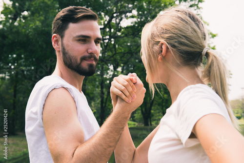 Happy young couple arm restling in the park photo