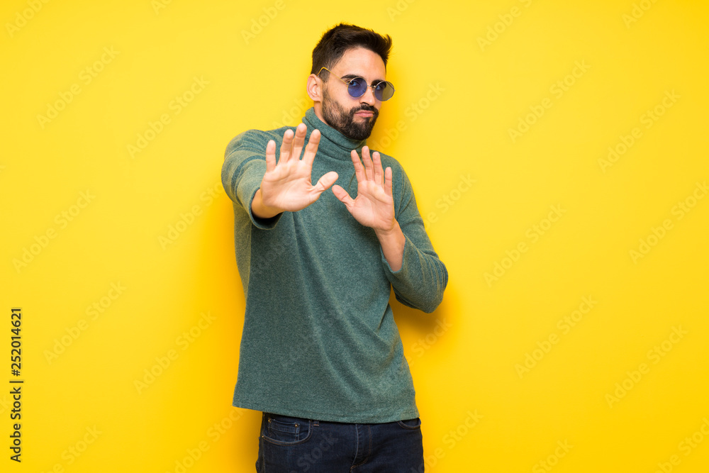 Handsome man with sunglasses is a little bit nervous and scared stretching hands to the front Handsome man with sunglasses is a little bit nervous and scared stretching hands to the front