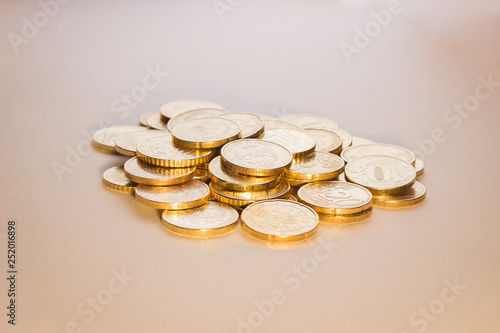 a handful of coins, similar to gold, lies on a white background