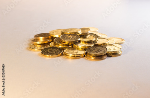 a handful of coins, similar to gold, lies on a white background