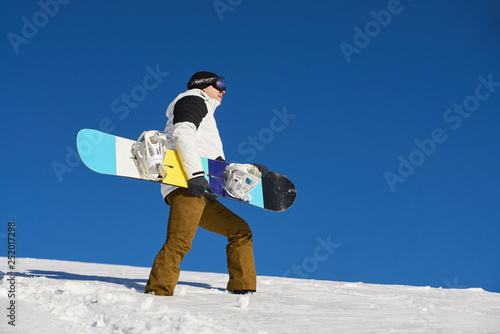 The guy is coming and preparing for skiing with snowboard