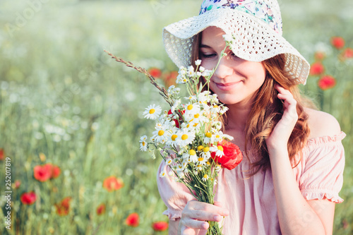 Beautieful young girl in the field of wild flowers photo