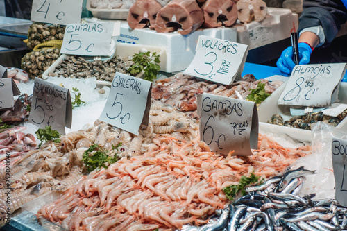 Squilla mantis, flying fish, red mullet, prawns, clams and anchovy at a fish stand in the market photo