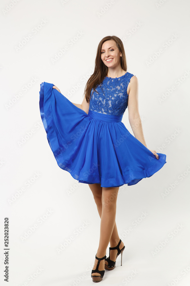 Full length photo of fashion model woman wearing elegant evening dress gown posing isolated on white wall background studio portrait. Brunette long hair girl. Mock up copy space. Blue dress face view. Full length photo of fashion model woman wearing elegant evening dress gown posing isolated on white wall background studio portrait. Brunette long hair girl. Mock up copy space. Blue dress face view.