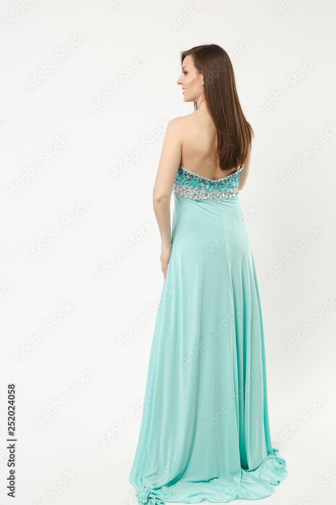 Full length photo of fashion model woman wearing elegant evening dress blue gown posing isolated on white wall background studio portrait. Brunette long hair girl. Mock up copy space. Back rear view.