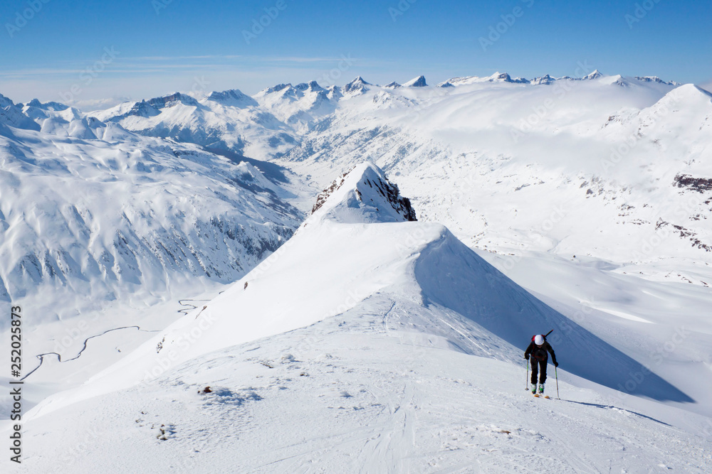 woman going up a mountain in a touring ski day