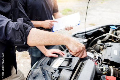 checking vehicle engine at the garage industrial concept, Hands of auto mechanic checking in a car with open hood.