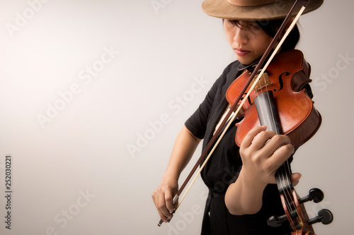 Beautiful young woman with violin over black background photo