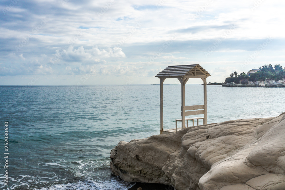 Arbor on the rock near the beach with beautiful waves. Cyprus, February 2019.