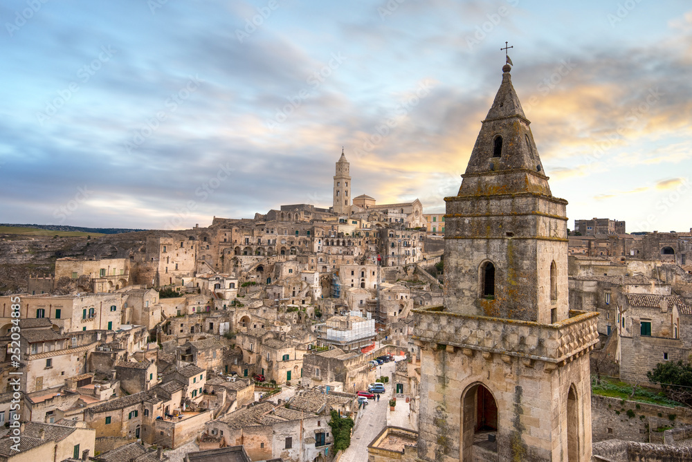 Matera, Basilicata, Italy, landscape at sunset of the old town (sassi di Matera), European Capital of Culture. Church San Pietro Barisano and duomo cathedral. Unesco World Heritage site