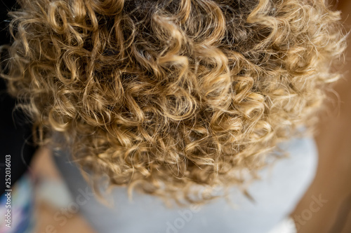 Obraz na plátně blonde hair curls close-up in beauty salon